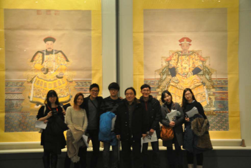 In front of portraits of two of the most revered emperors of the Qing Dynasty, Qianlong (left) and Kangxi (right)