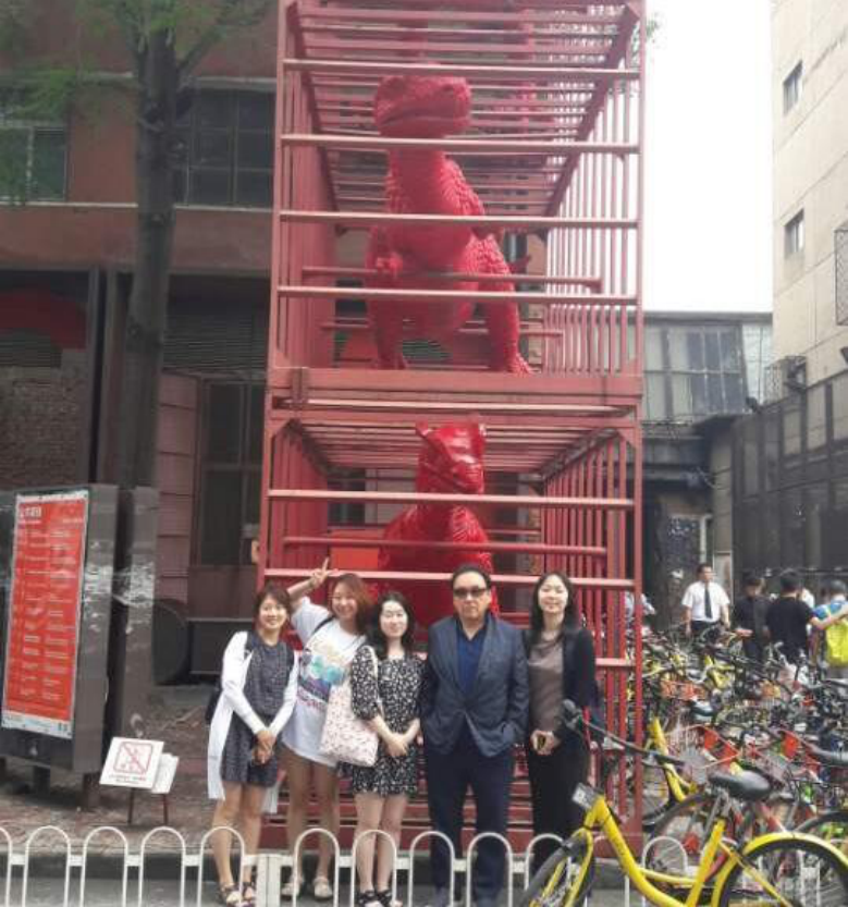 In front of the dinosaur sculpture at UCCA.